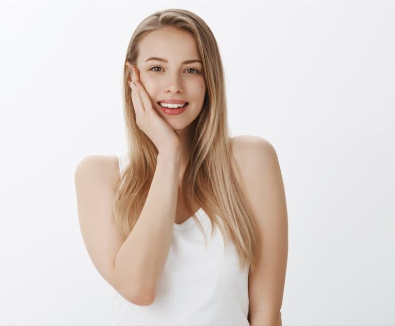 girl with clear skin, with one hand on her right cheek